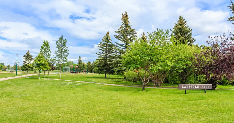Lakeview Park sign in Saskatoon, set in an open green space with mature trees